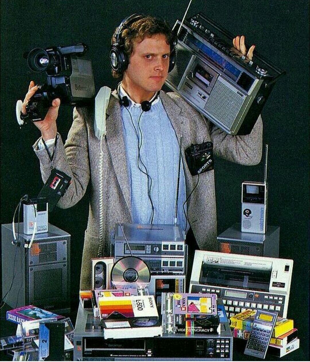 Image showing a man surrounded by tech gadgets from the 1980s and 90s